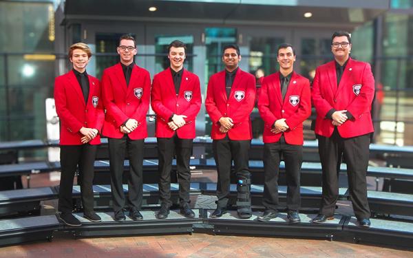 Six MGC members in red blazers 2024